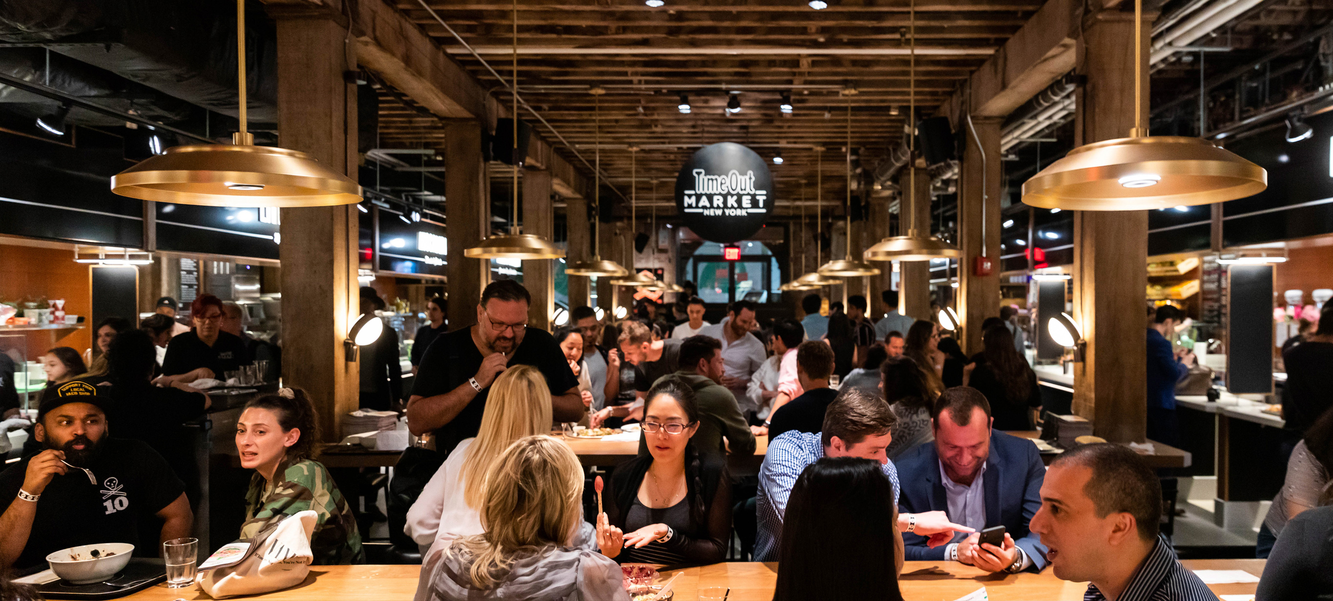Busy scene of Time Out Market New York with diners at communal tables